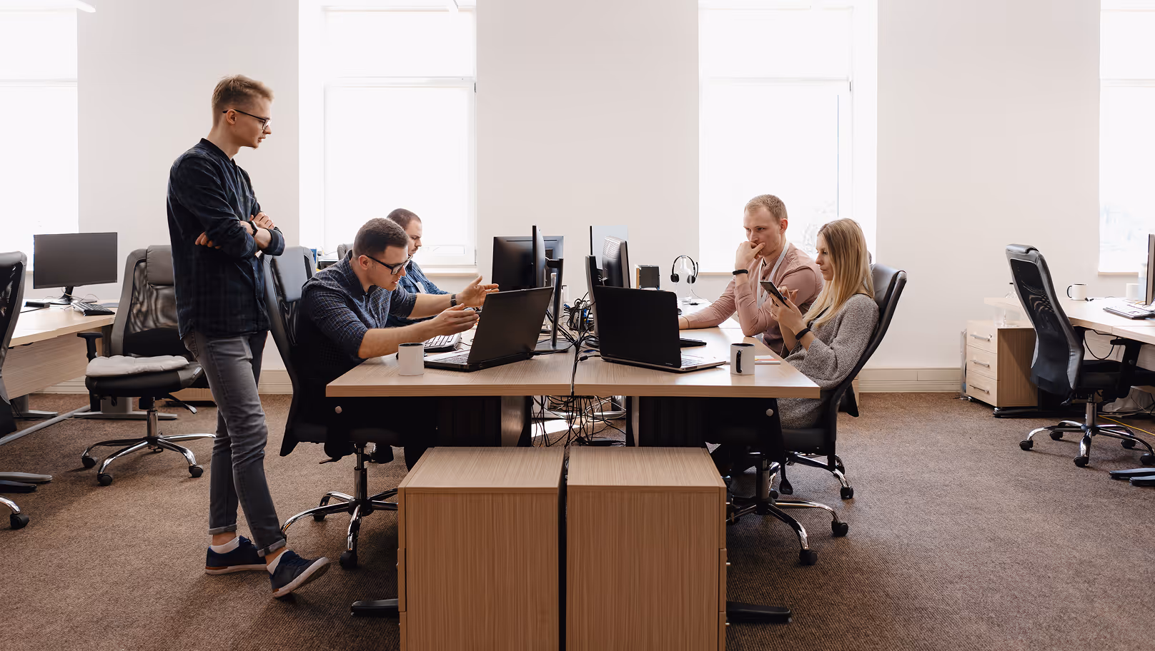 Équipe en réunion de travail autour d'un bureau partagé